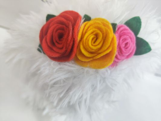 Белая собака с цветами и колокольчиками на голове. Детская игрушка.